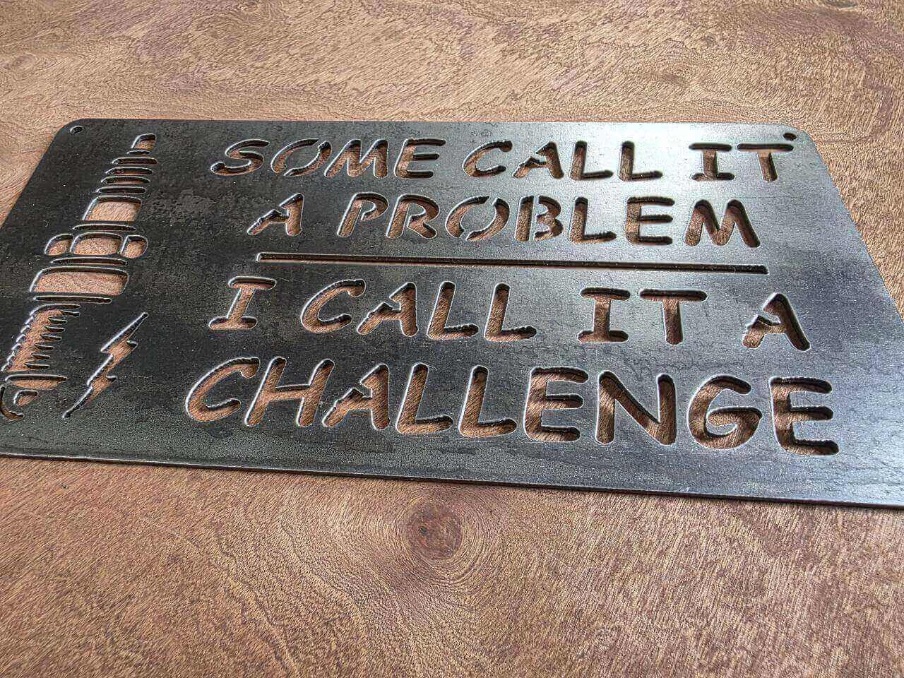 Low-angle view of spark-plug challenge quote metal sign