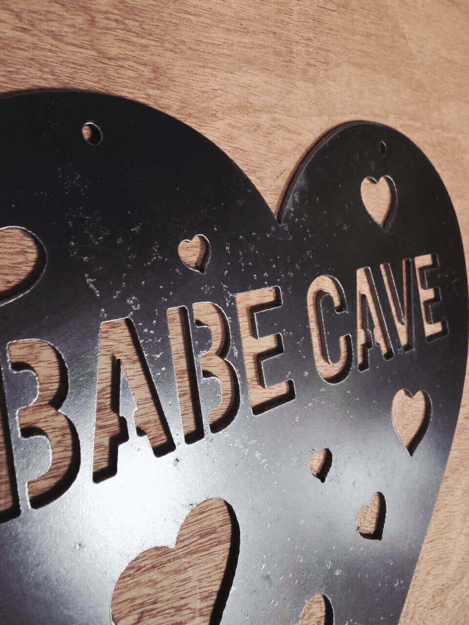 Angled detail of 2.5 mm raw steel Babe Cave sign