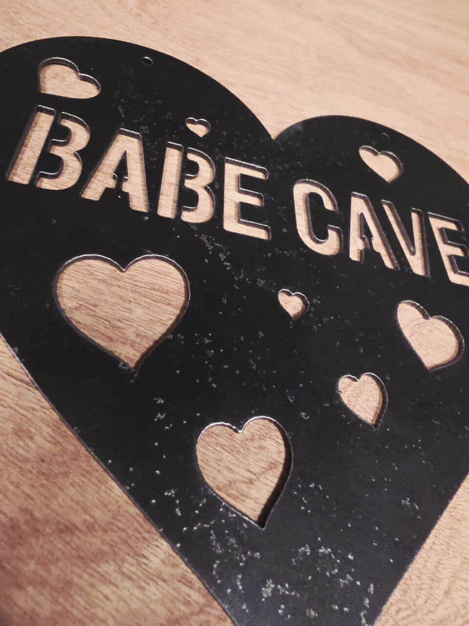 Close-up of plasma-cut Babe Cave lettering and heart details