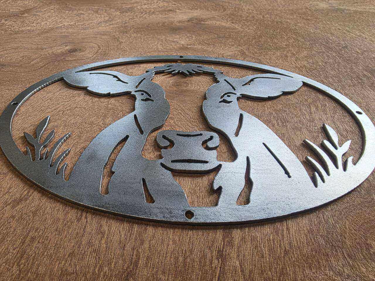 Angled view of cow metal wall art