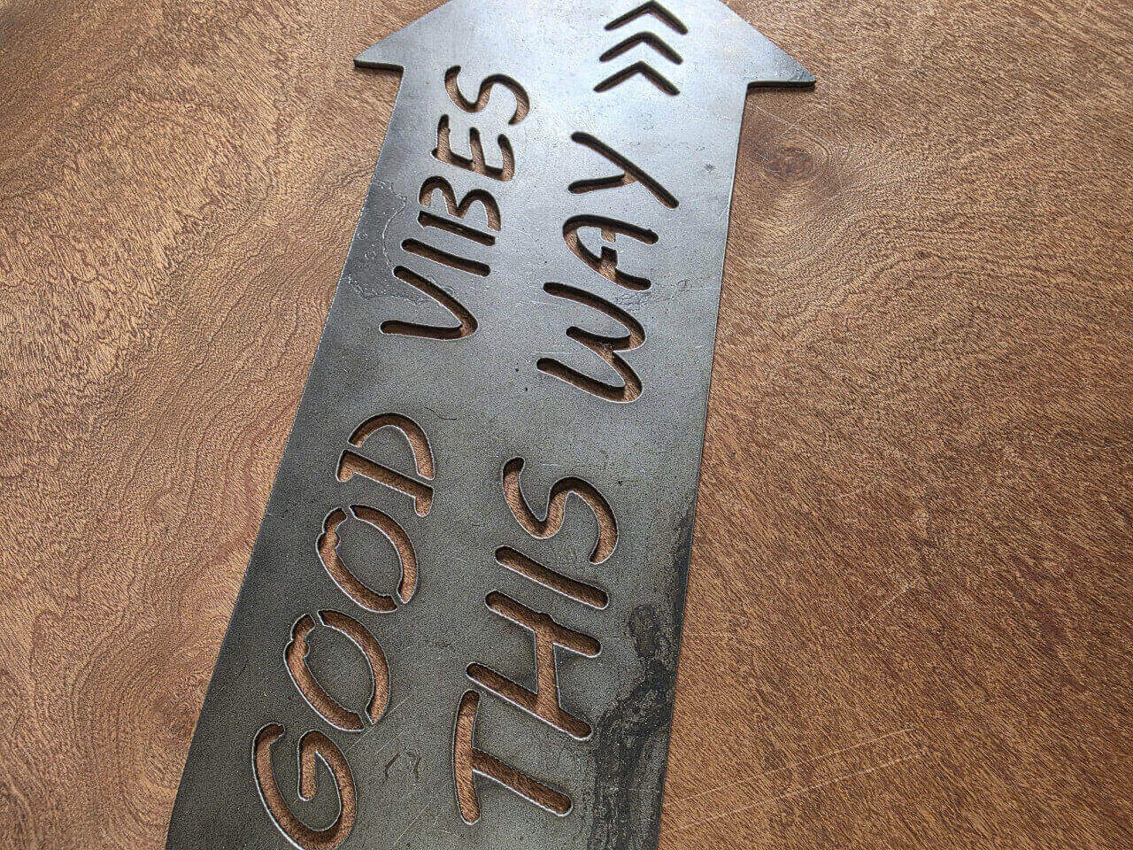 Detail of Good Vibes This Way cut-out lettering in raw steel