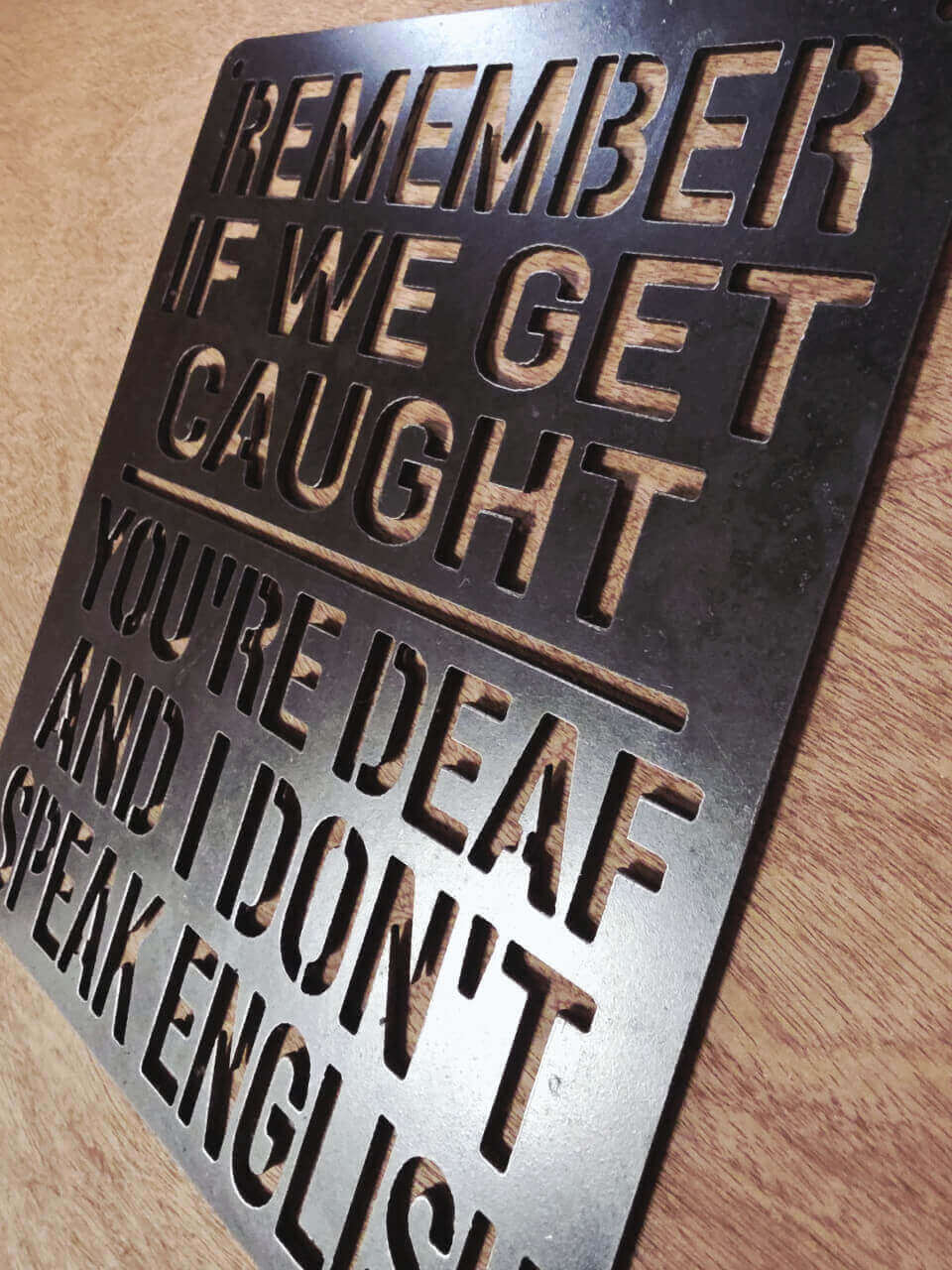 Angled view showing raw steel finish on funny wall sign