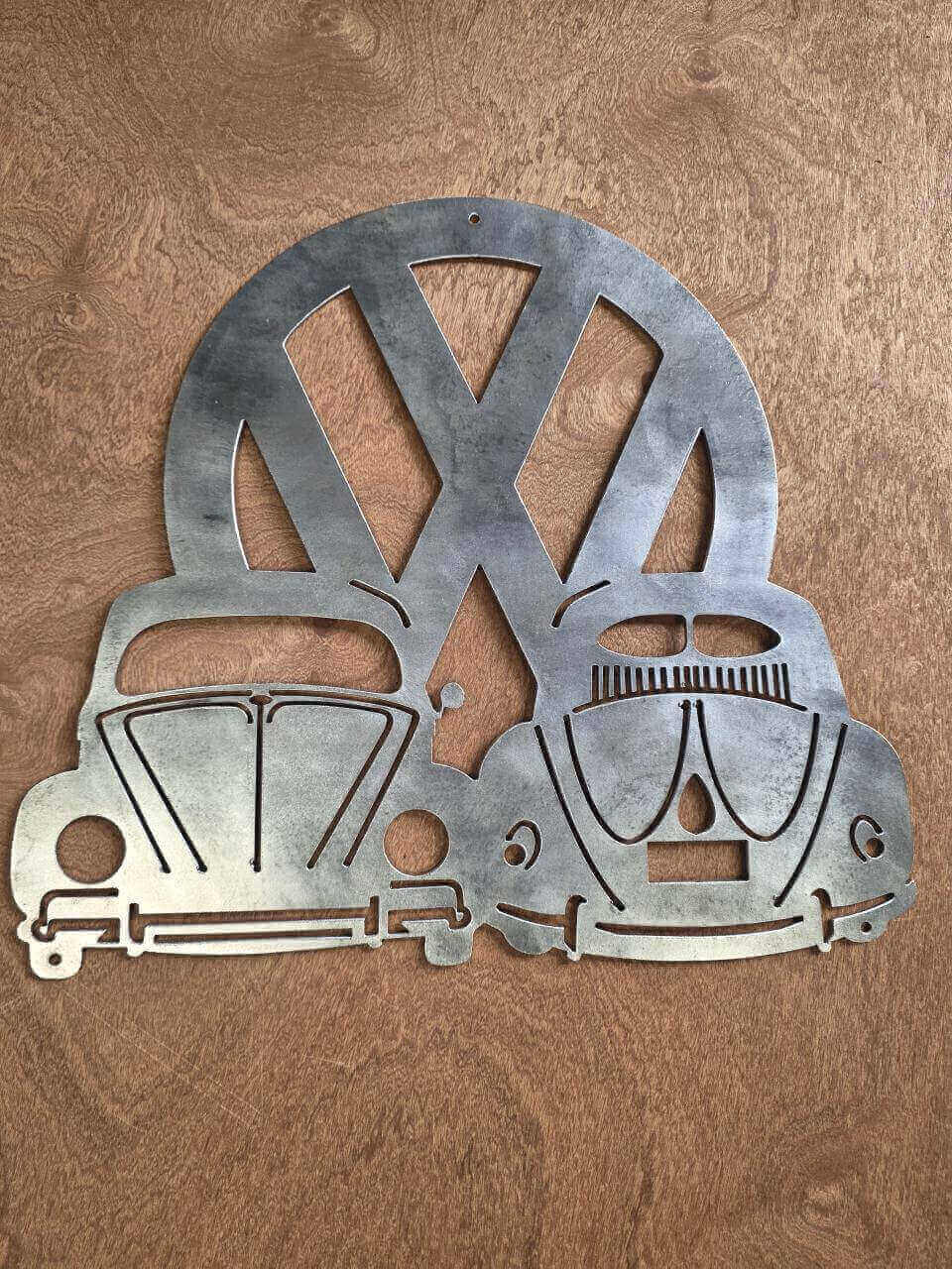 Raw steel VW Beetle wall art with the front on the left, rear on the right and VW logo behind