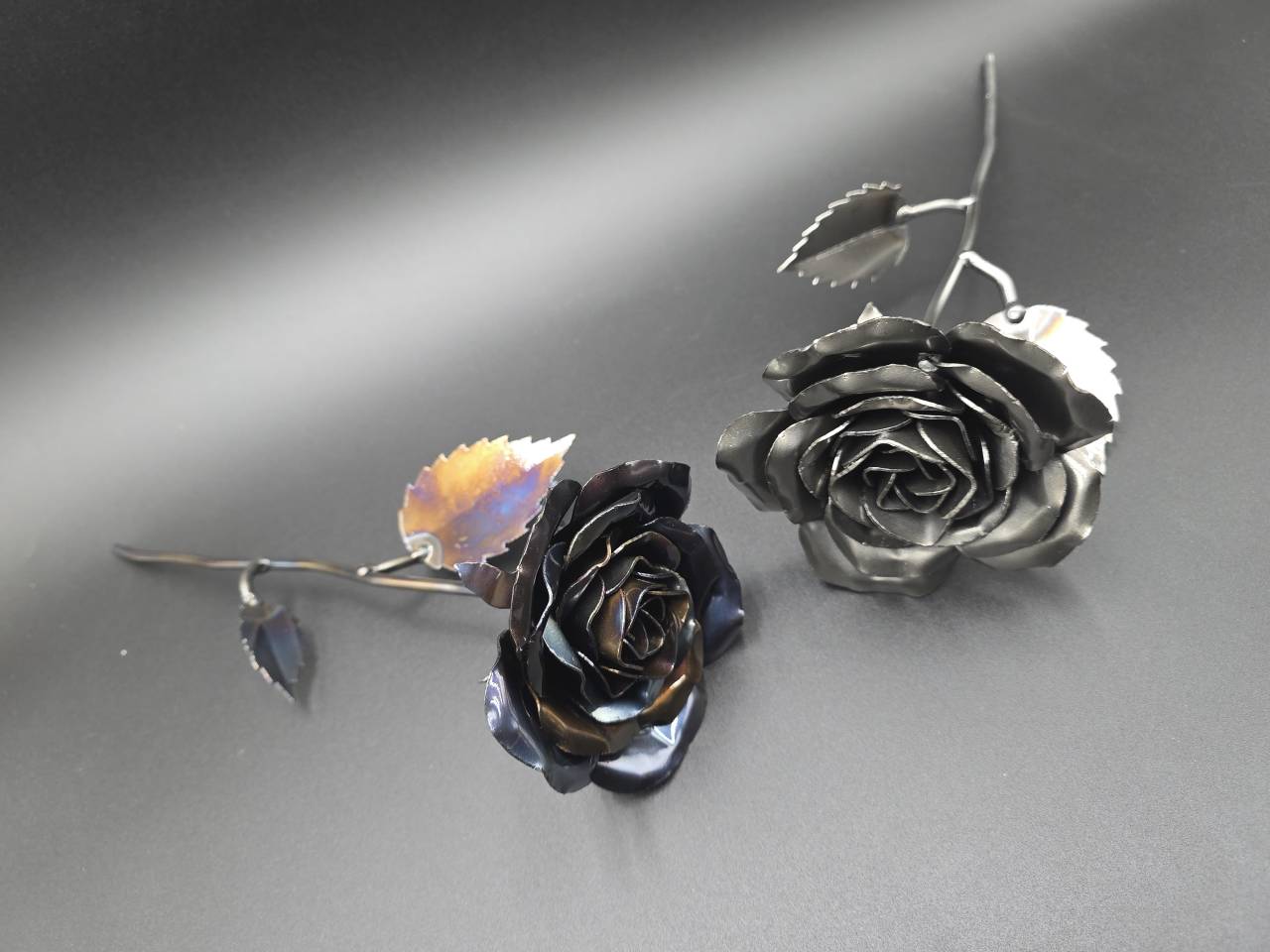 Raw-steel and heat-treated metal roses showing their handmade petals and leaves