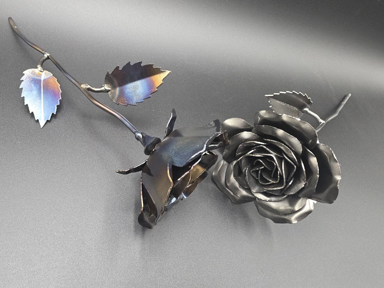 Handmade steel roses showing silver-grey and colourful heat-treated finishes