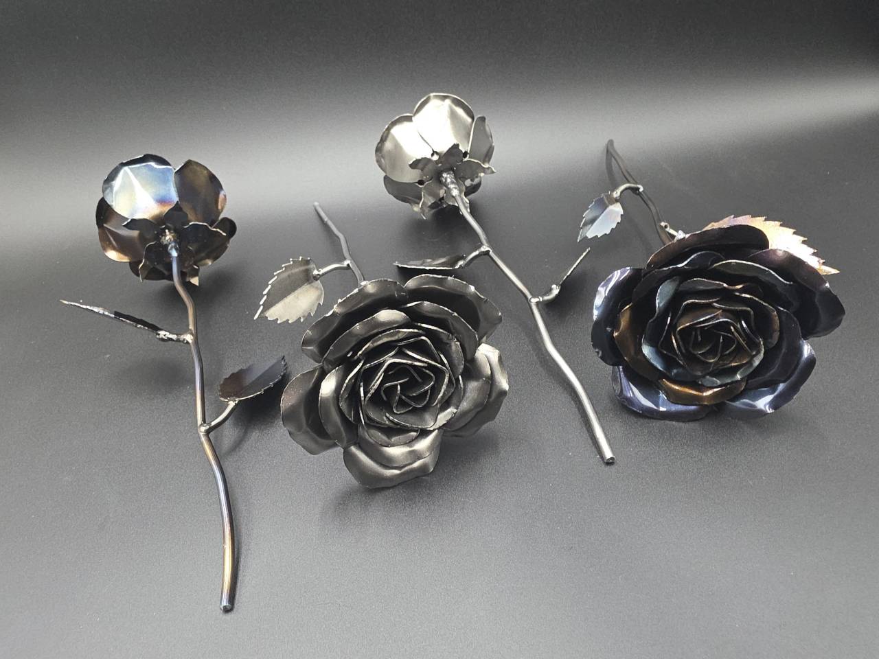 Three Eternal Steel Roses displayed with their full stems and metal leaves