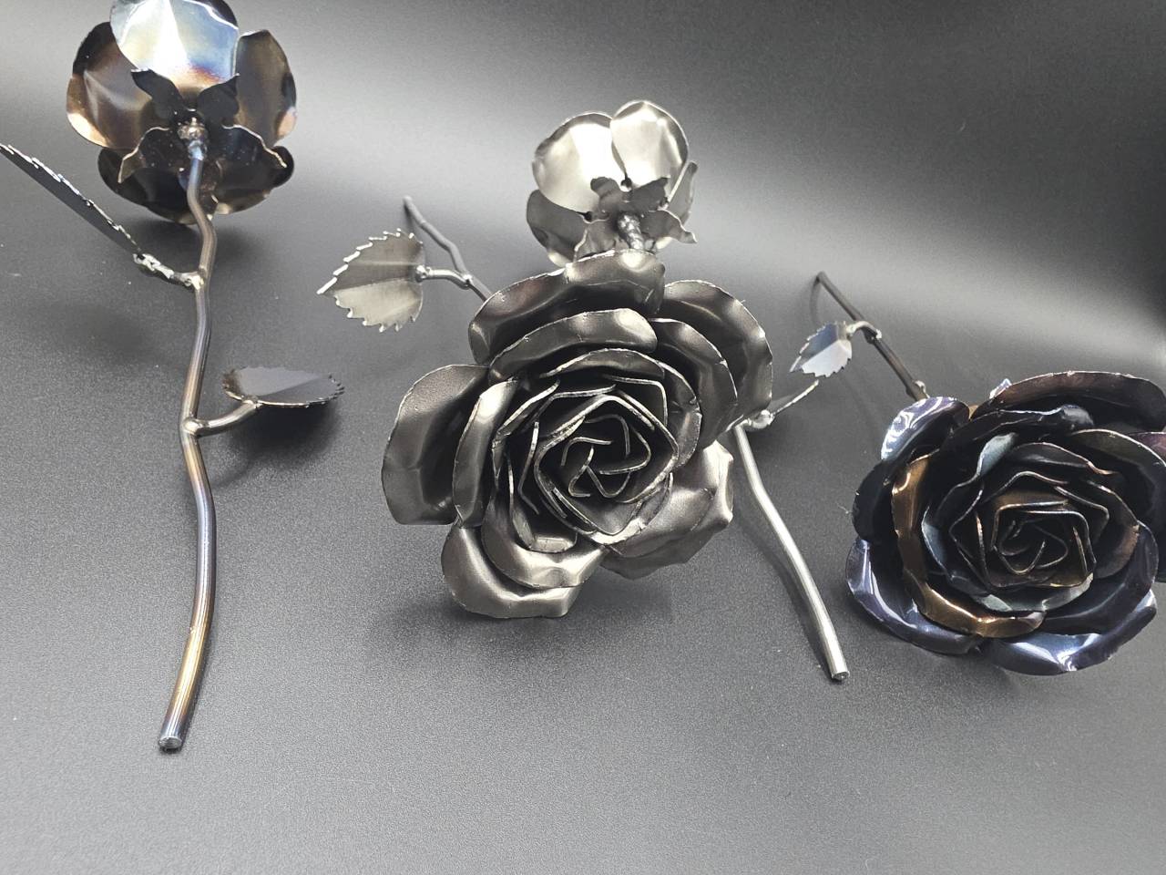 Group of individually hand-formed steel roses with naturally varying shapes