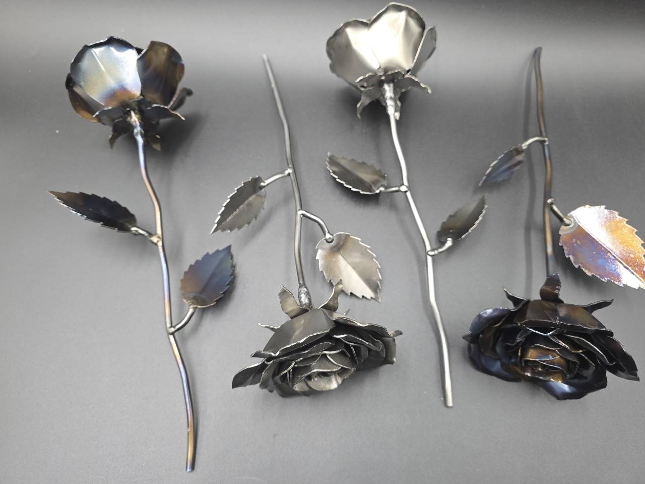 Rear view of handmade steel roses showing the stems and formed petal construction