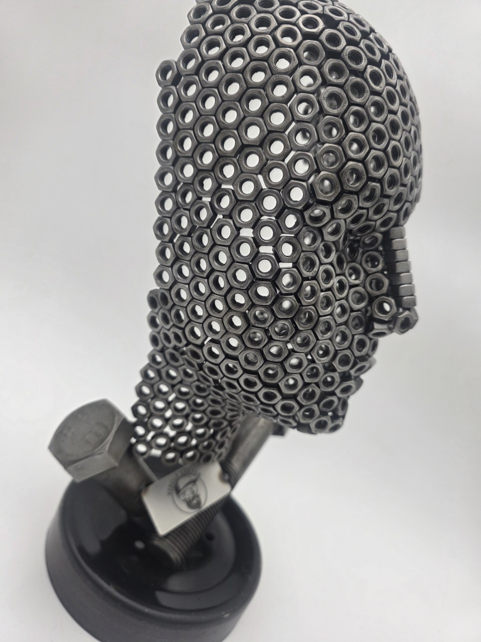 Opposite side view of Fred the Head life-sized nut sculpture on its reclaimed metal base