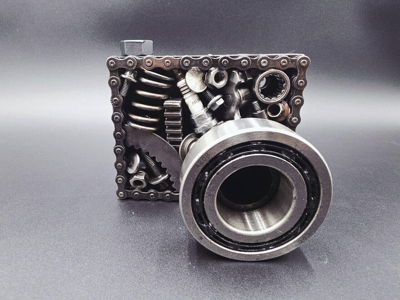 Front view of scrap metal camera sculpture with large bearing lens