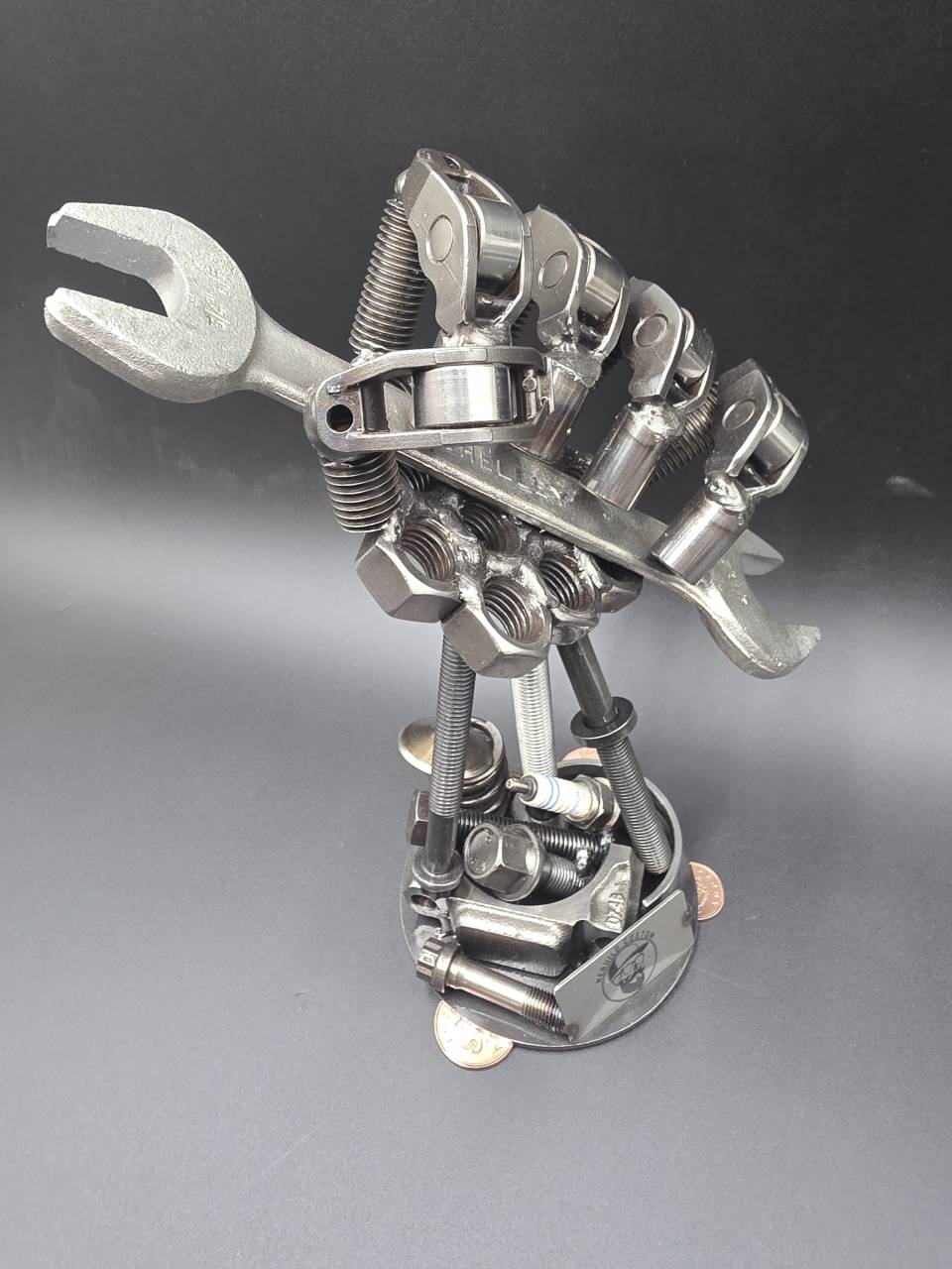 Side view of the reclaimed steel hand sculpture gripping a spanner