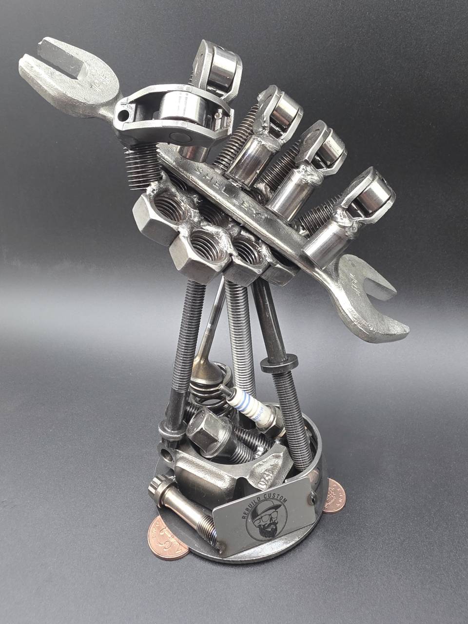 Full side view of the one-off scrap metal hand sculpture on its workshop-style base