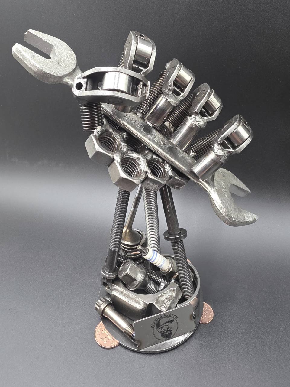 Angled view of the mechanic’s hand sculpture holding an open-ended spanner