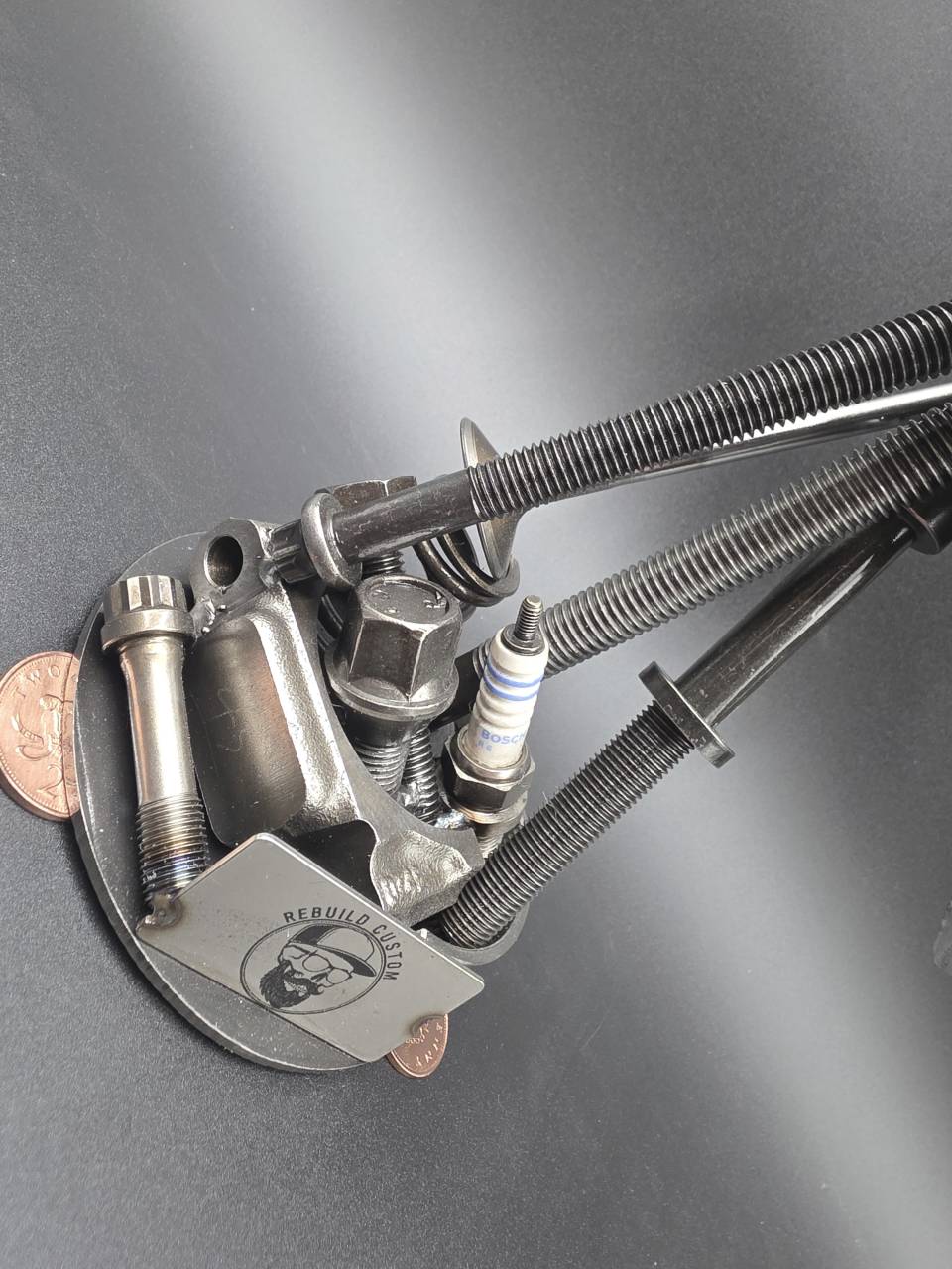 Detailed view of the reclaimed mechanical parts and coin-supported sculpture base