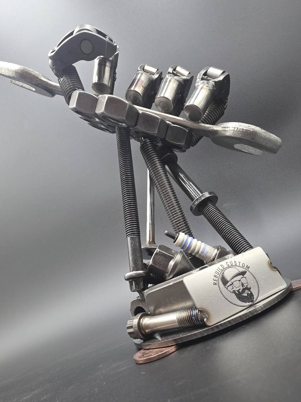 Back view of the scrap metal hand showing steel fingers bolts and spanner