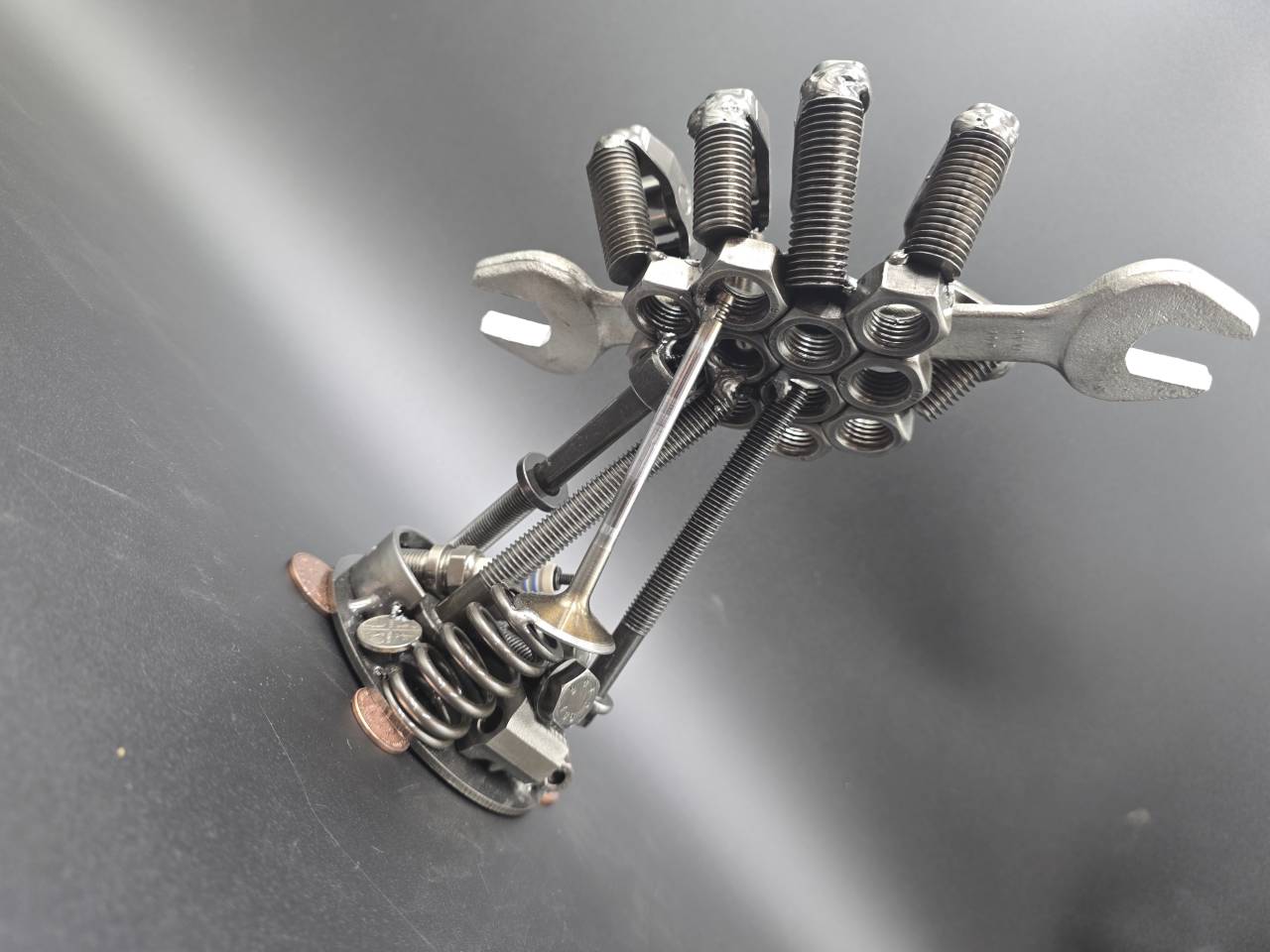 Overhead rear view of the hand sculpture showing springs fasteners and spanner
