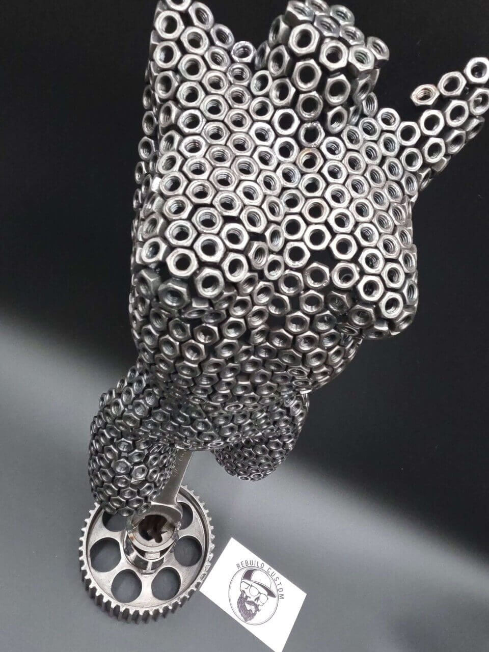 Close angled view of the M6 nut torso sculpture and reclaimed automotive base