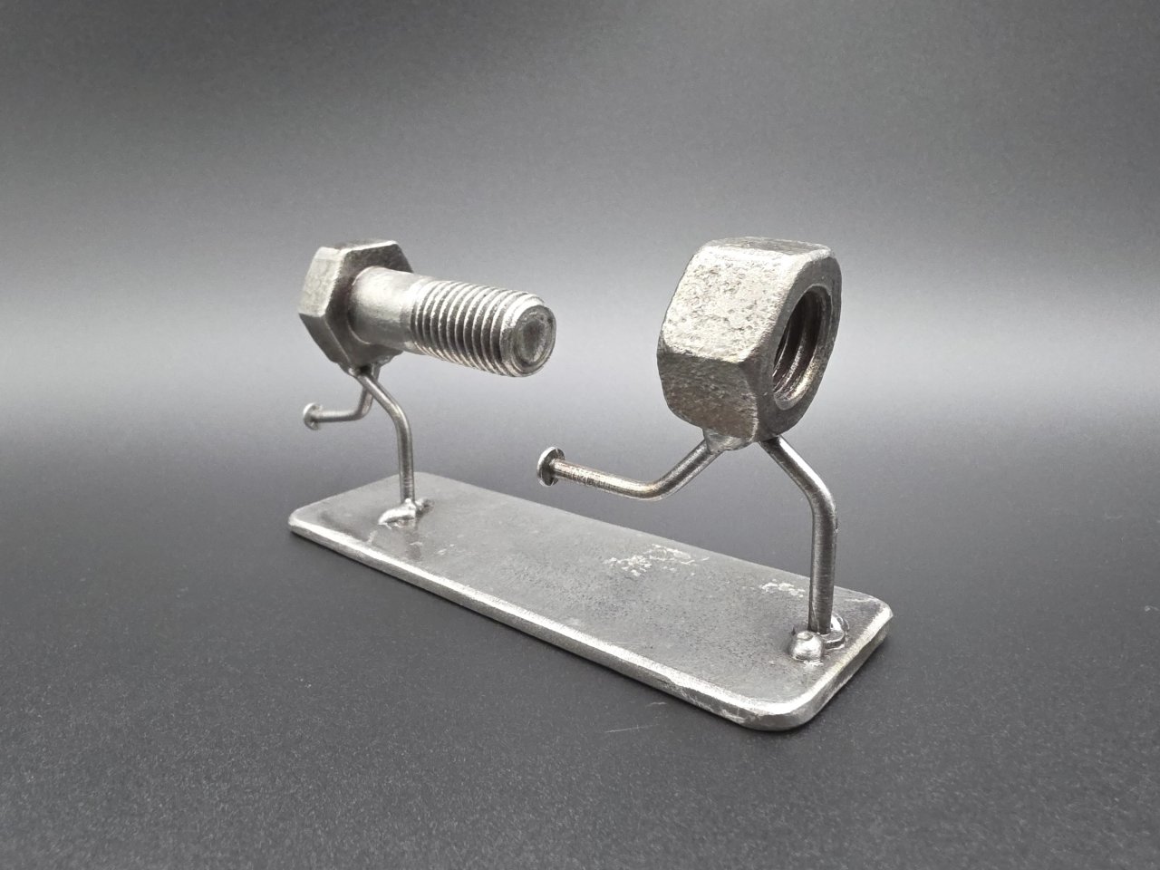 Bolt chasing a nut in The Chase reclaimed steel sculpture